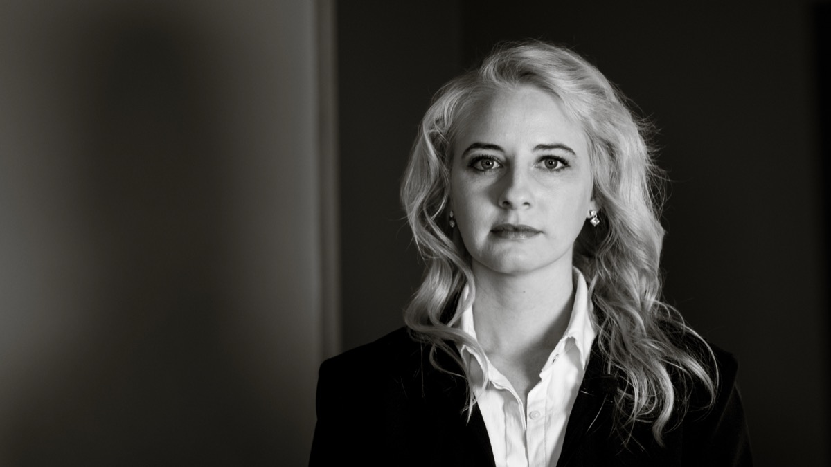 A striking black and white portrait of a professional woman with a serious and composed expression, representing expertise in web platforms and digital solutions.