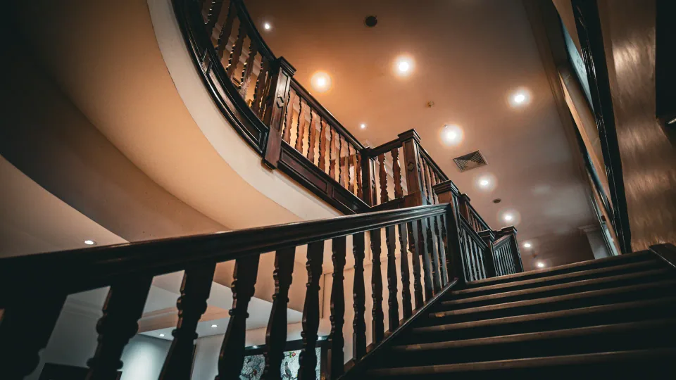 A curved indoor staircase with wooden balustrades.